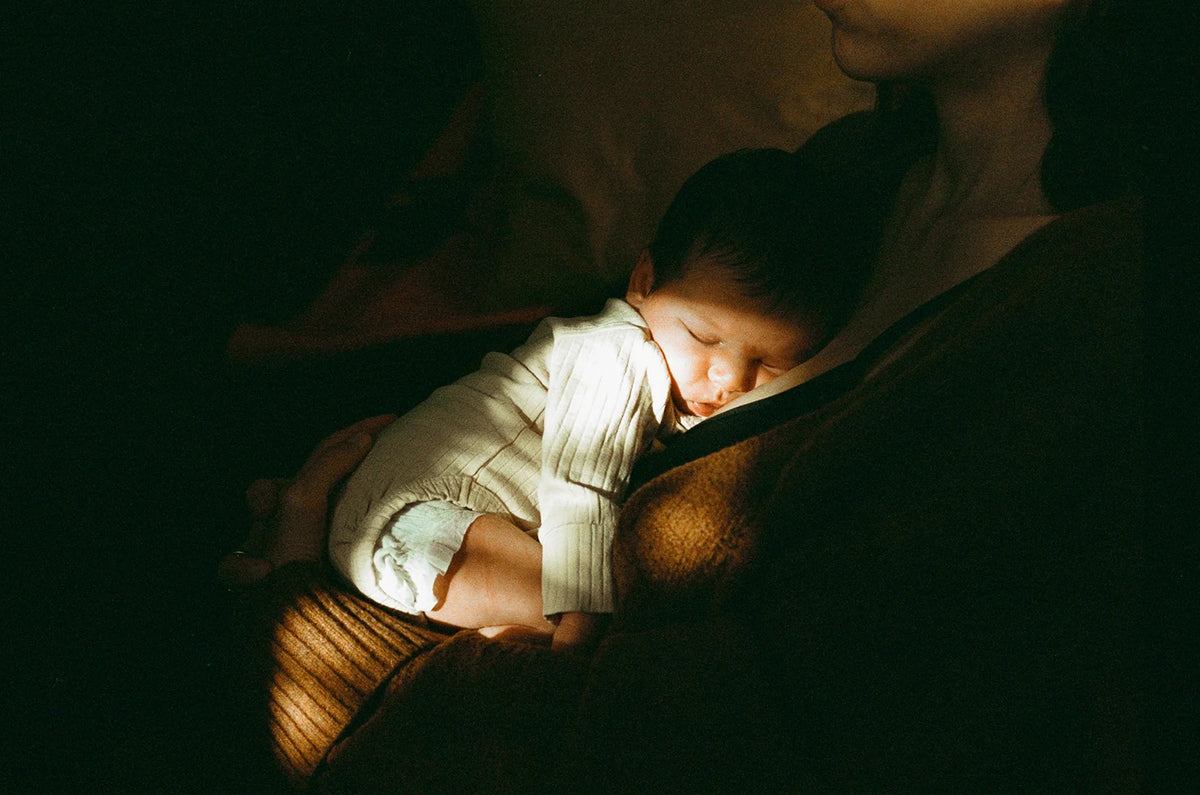 Mom holding her baby on her chest during a night feed