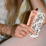 Postpartum mom holding Mamamind snack pouch – clarity and energy support