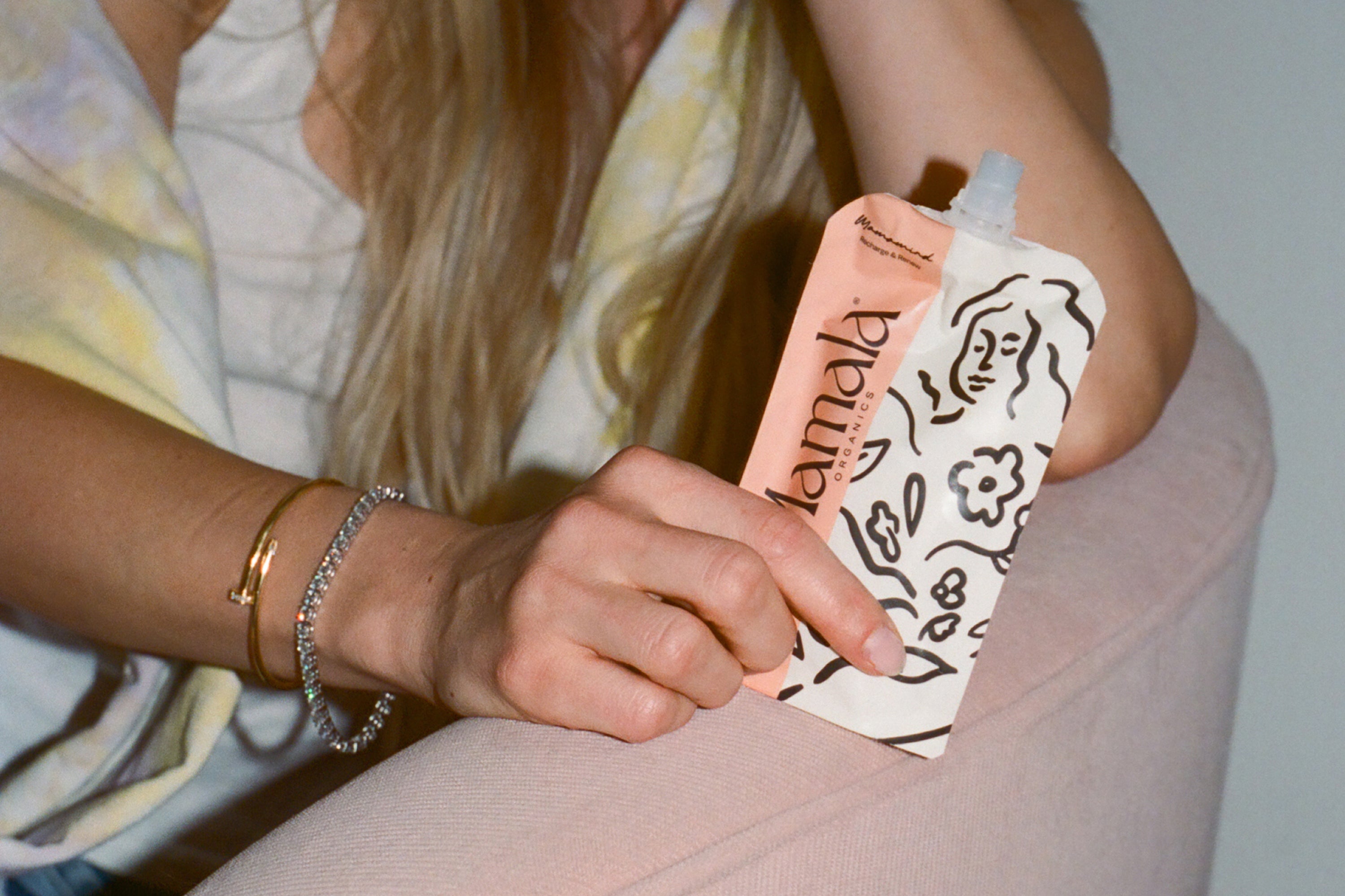 Postpartum mom holding Mamamind snack pouch – clarity and energy support